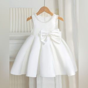 Sleeveless bow dress for girls. White with pearl detail